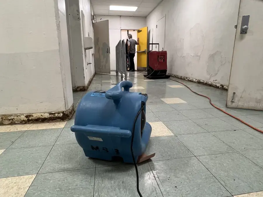 Air mover drying a wet tile hallway during water damage restoration in El Monte